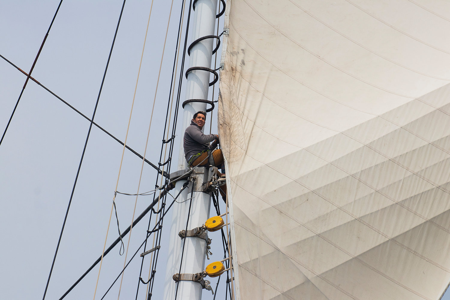 A crewman aboard the Columbia, a Herreshoff racing schooner owned by Martin Sutter of the CCA and NYYC, prepares a sail.