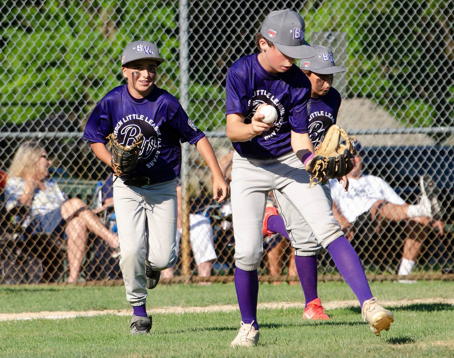Kevin Casey (left), Parker DeWolf and another player start out to their positions to start the game.