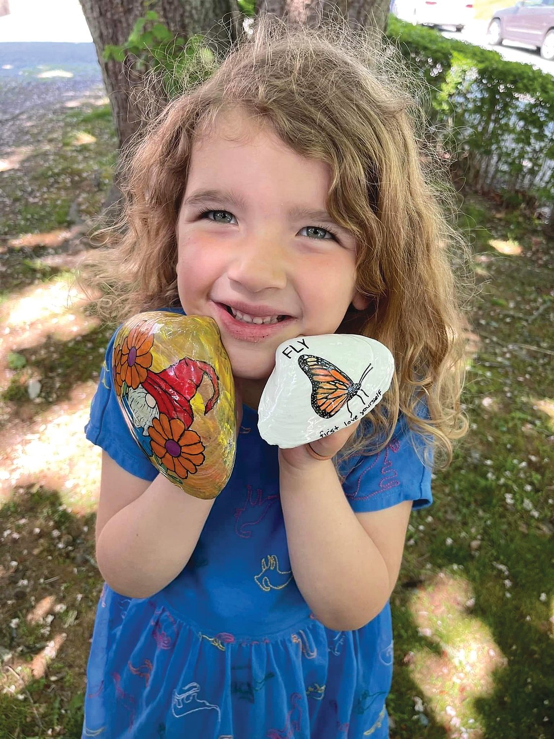 Addie Loveland shows off two of the painted shells. People taking part in the project both find and paint shells, often posting them to a group Facebook page.