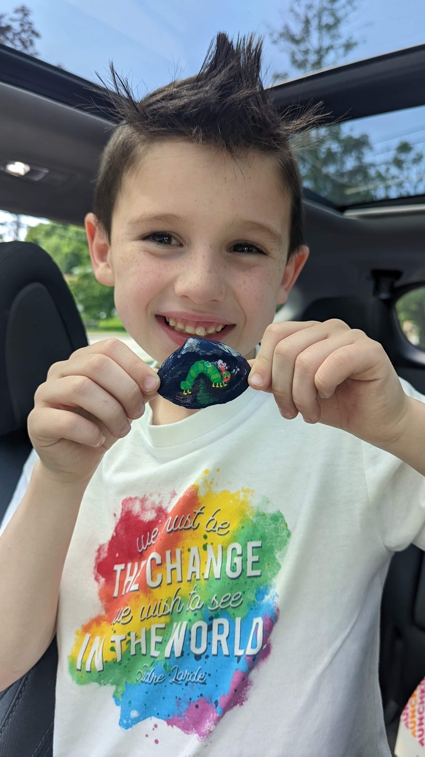 Jaxon Arbige shows off a small painted shell with an inchworm.