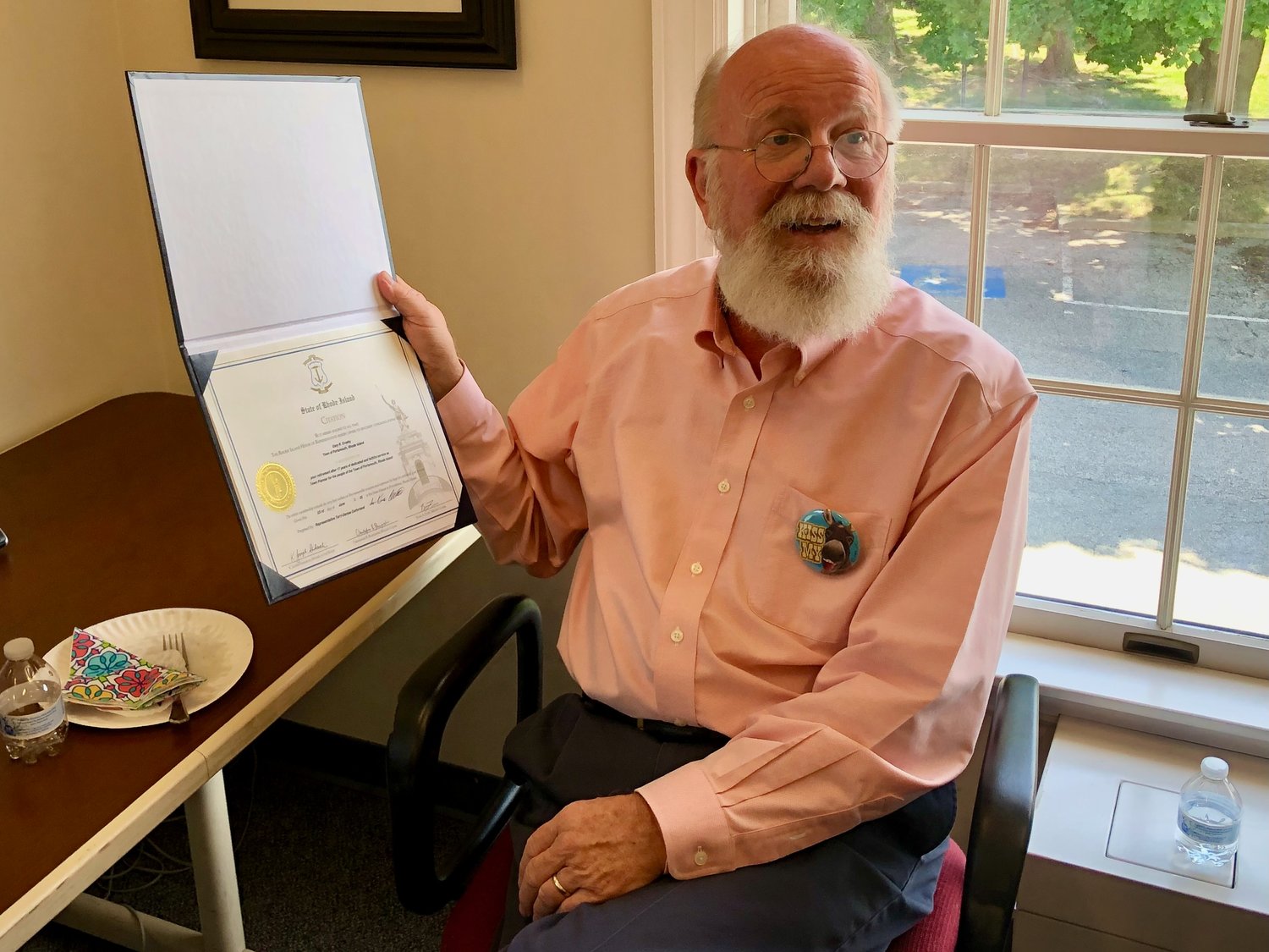 At a retirement sendoff at Town Hall Thursday, Town Planner Gary Crosby holds up a citation from the R.I. House of Representatives that Rep. Terry Cortvriend had just presented him.