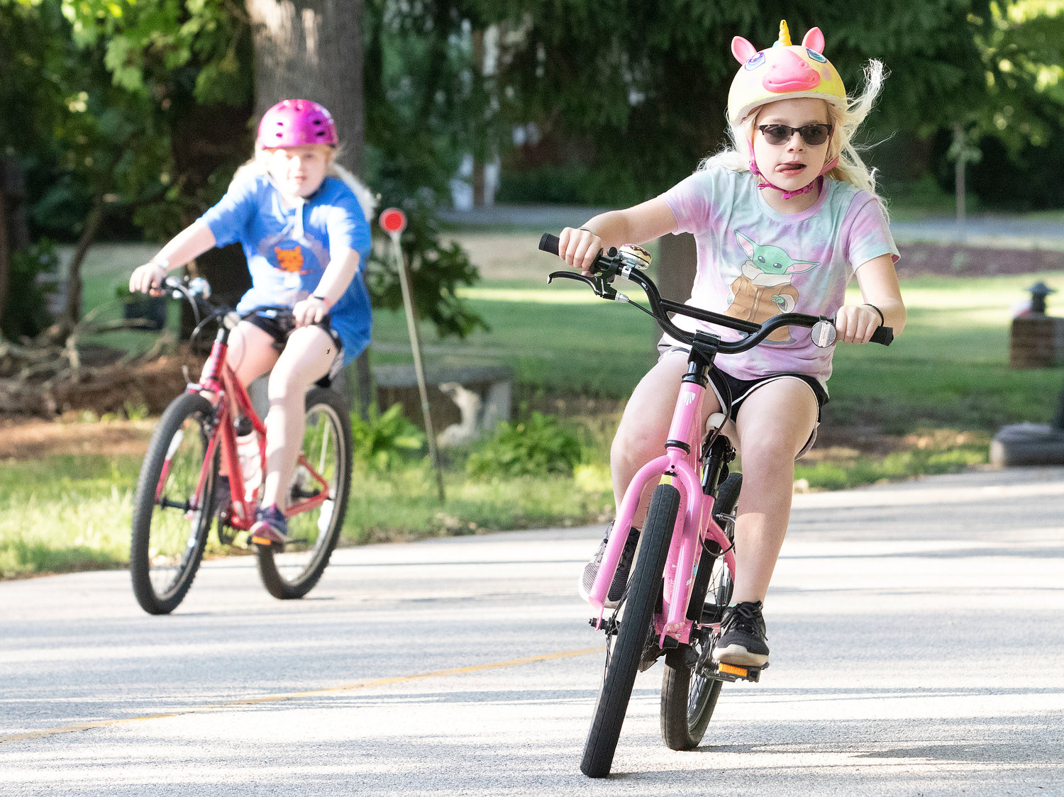 Clara Streit, 7, bikes down Stratford Road with sister, Anna, 11, (back left) as bikers work their way through the course.
