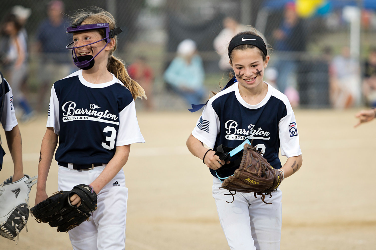 Lucy Loverme and Layla Kupperman run off the field, smiling, after a successful first inning against Middletown.