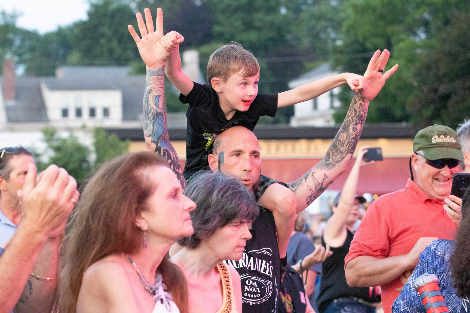Matthew Oliveira (middle) and son, Leo (top) cheer on the band.
