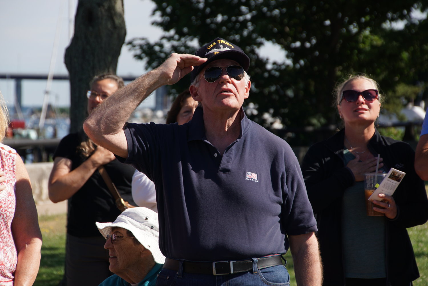 John Higginbotham, a United States Navy veteran who served on the USS Truitt and USS Suribachi, salutes as the crowd recites the Pledge of Allegiance Monday morning.