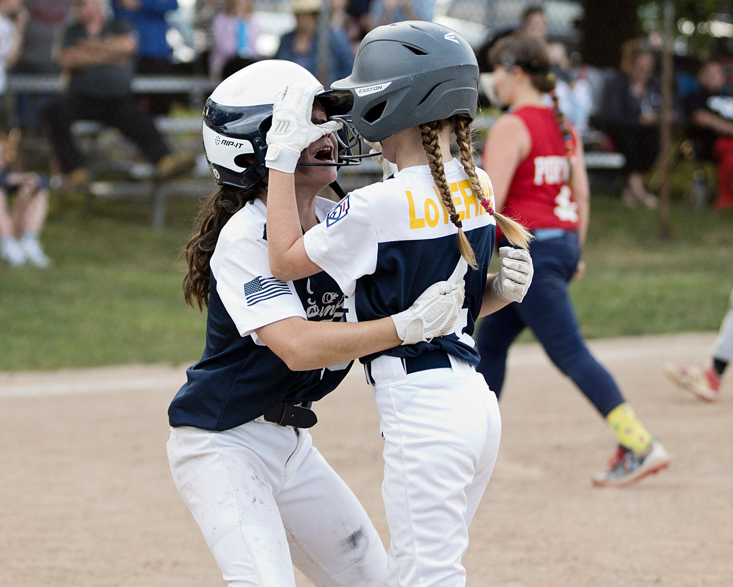 Barrington's Keira Martin (left) hugs Sky LoVerme after Sky drove in the winning run in the bottom of the sixth inning, in the District 2 All-Star Championship game.