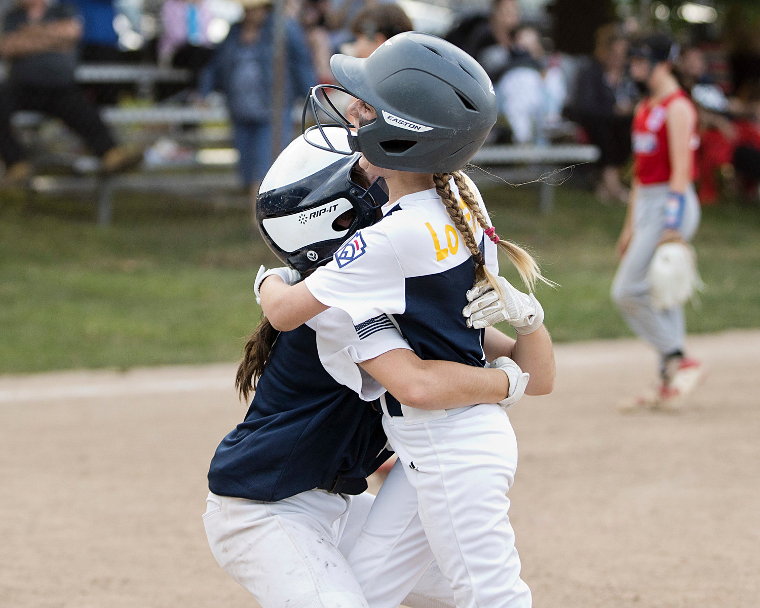 Keira Martin (left) hugs Sky LoVerme after Sky drove in the winning run in the bottom of the sixth inning the District 2 Championship All-Star game on Friday night.