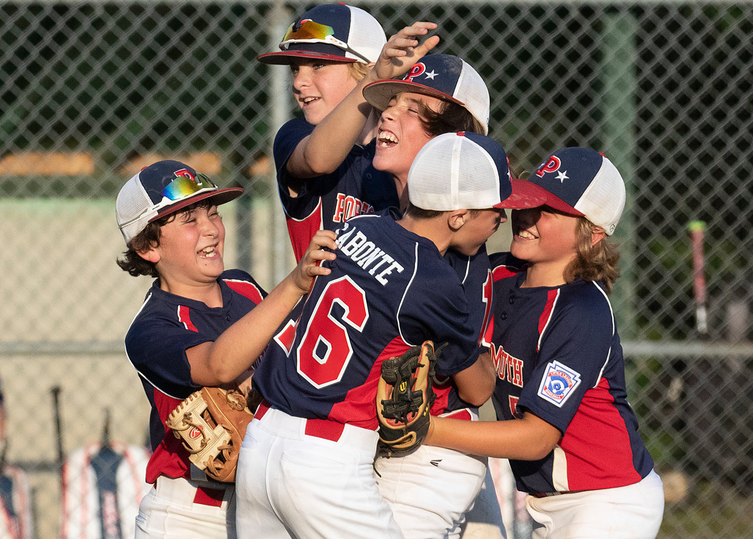 Portsmouth players, Carter Doran (left), Tyler Doucet, Jacob La Bonte and Kane Brule celebrate with pitcher Ben Humm (middle) after they beat Bristol-Warren and secure a spot in the District 2 championship at Sherman field on Saturday.