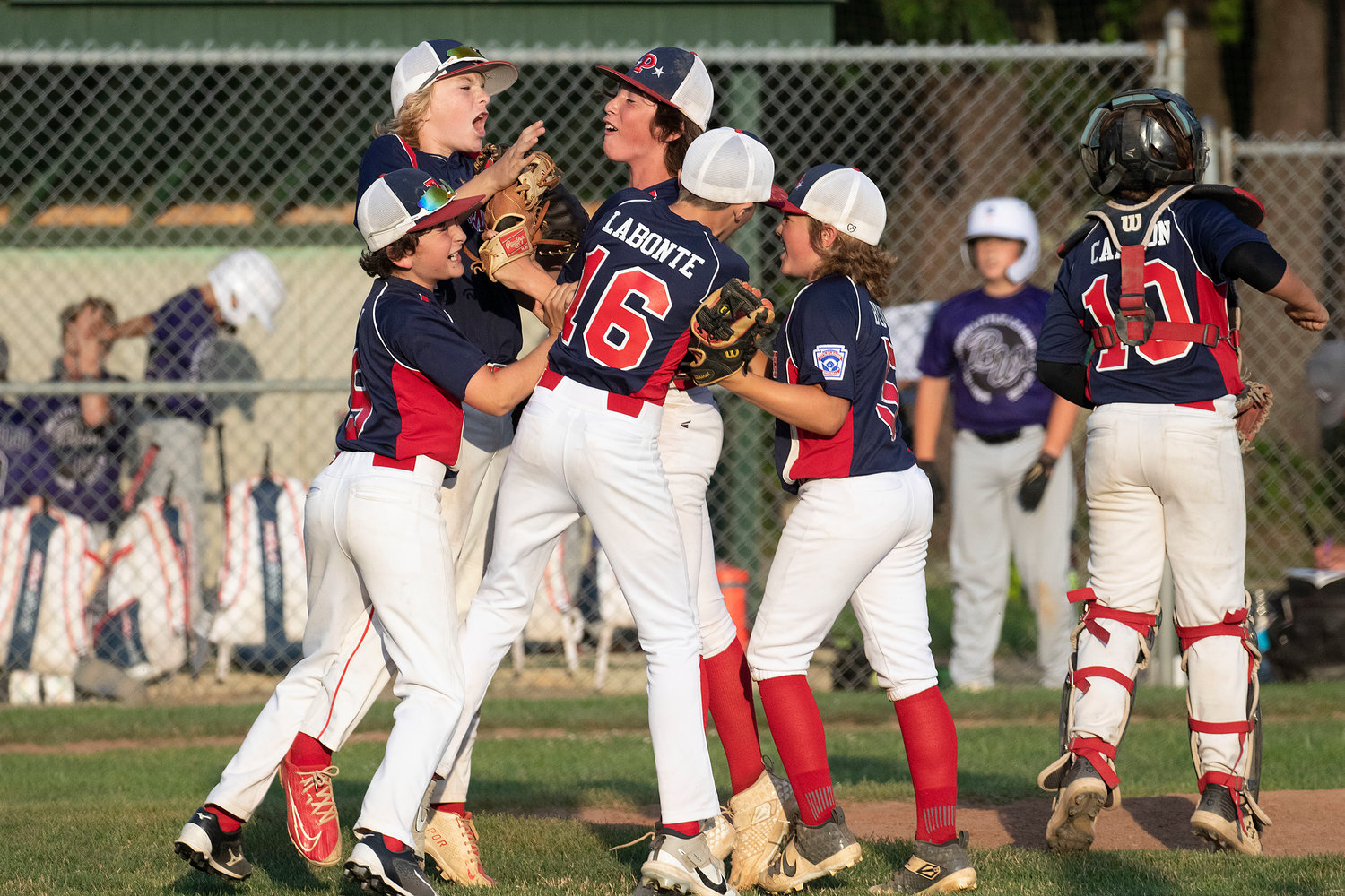Portsmouth players, Carter Doran (left), Tyler Doucet, Jacob La Bonte, Kane Brule and Ryan Campion celebrate with pitcher Ben Humm (middle) after they beat Bristol-Warren and secure a spot in the District 2 championship at Sherman field on Saturday.