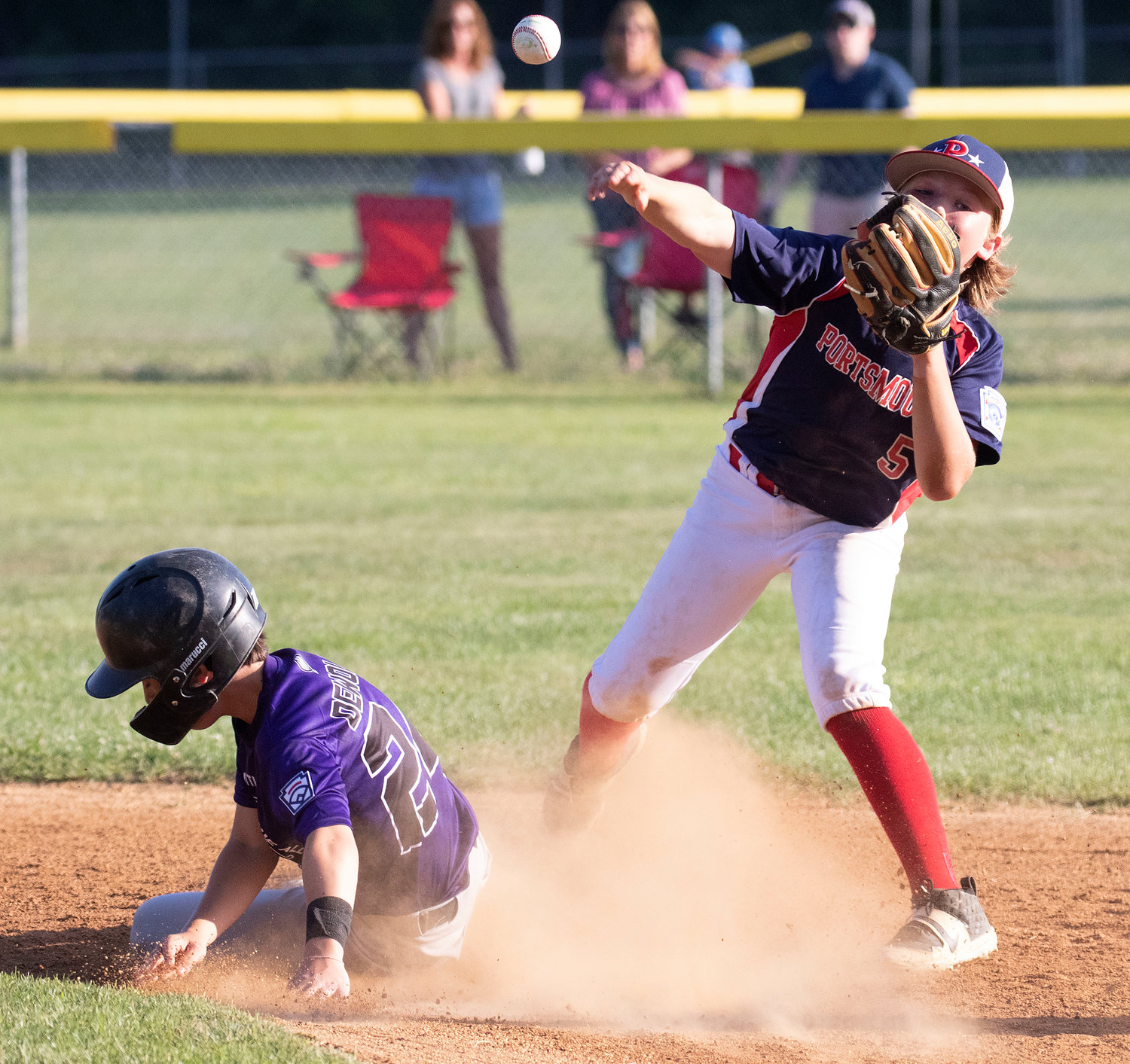 Parker DeWolf slides into second base as Portsmouth second baseman Kane Brule attempts to turn a double play.