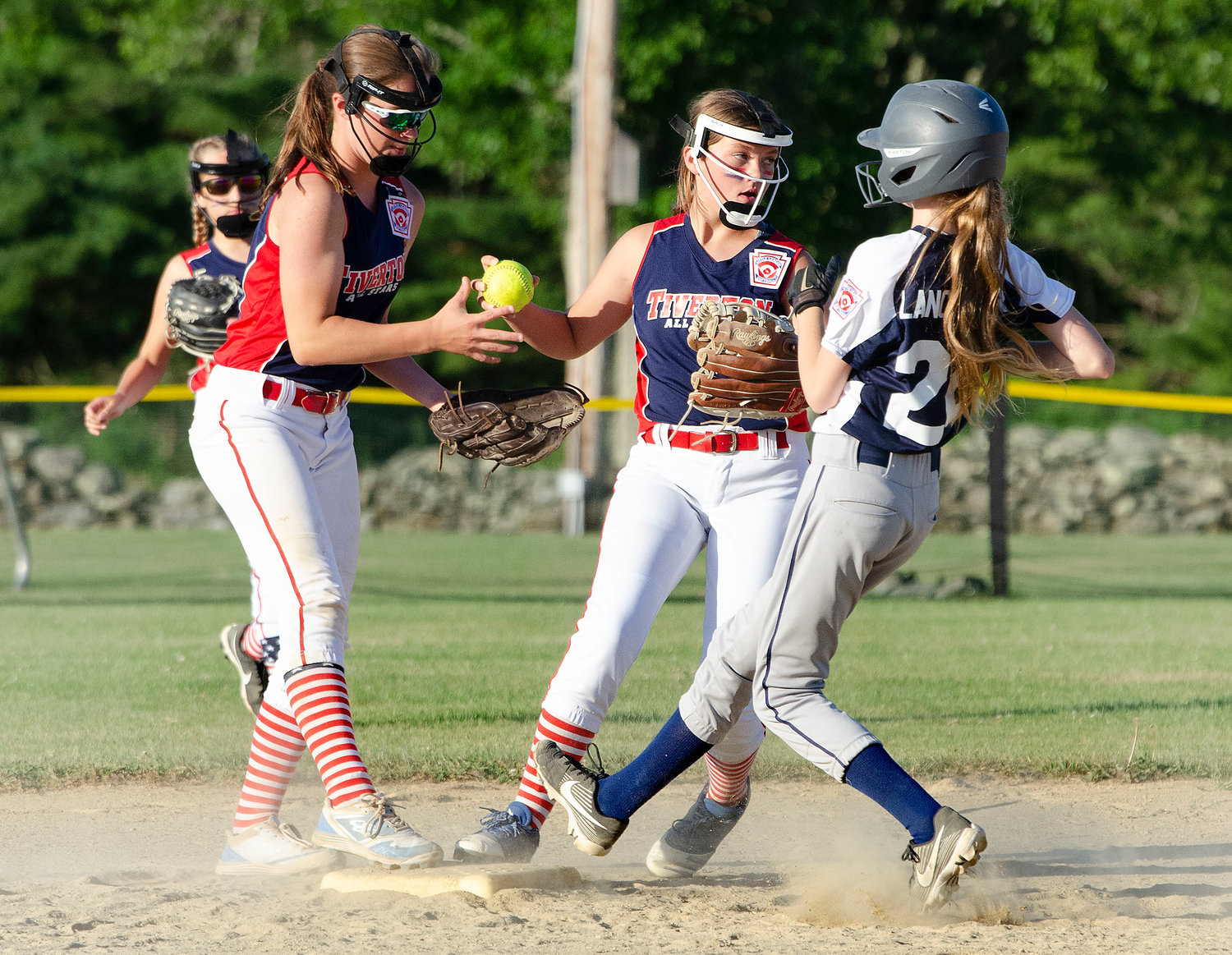 Shortstop Elodie Cannon (left) looks on as second baseman Brooke Sowa steps on second for an out and prepares to throw to first for a double play.