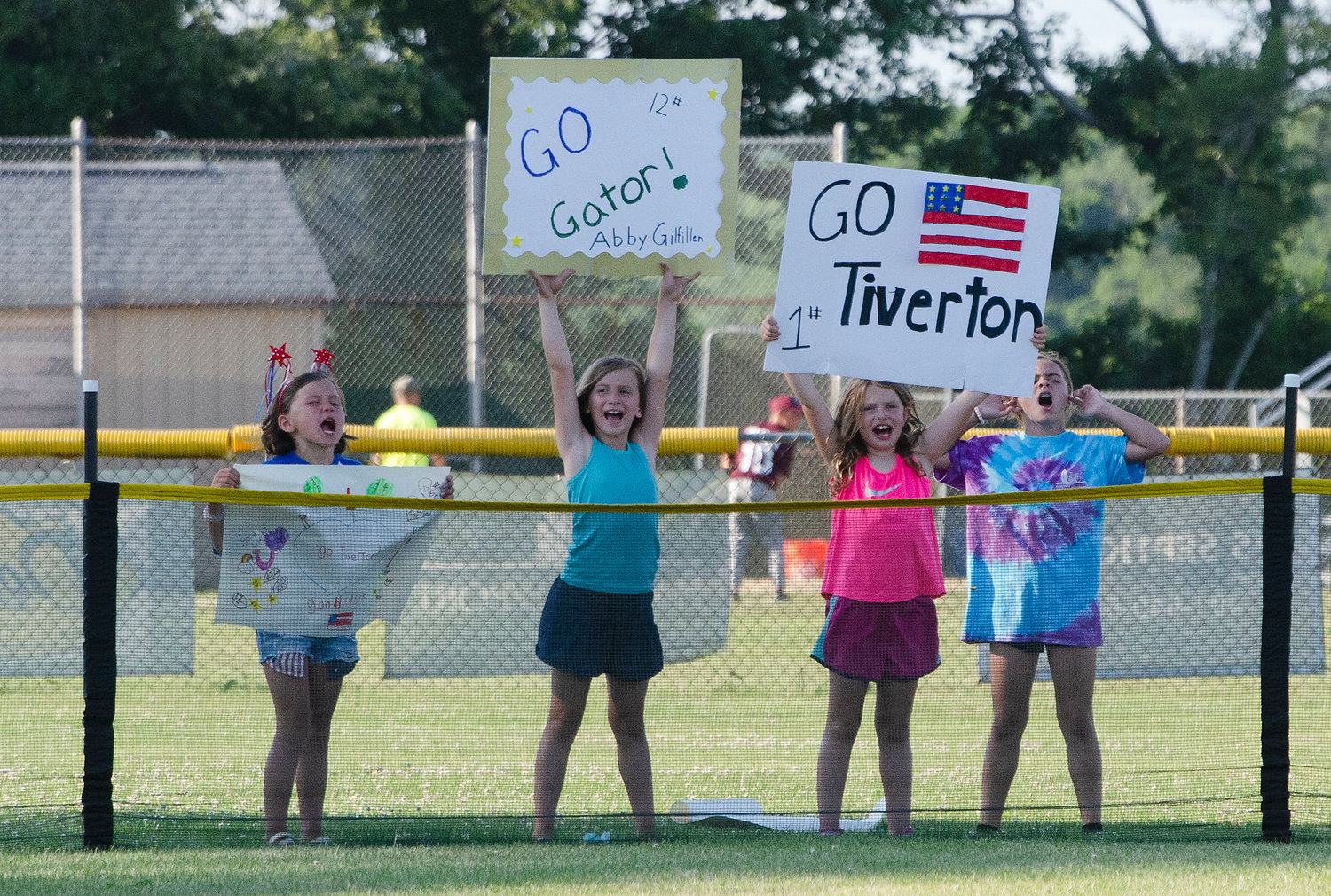 The Tiverton all stars super fans hold up signs and cheer in right field.