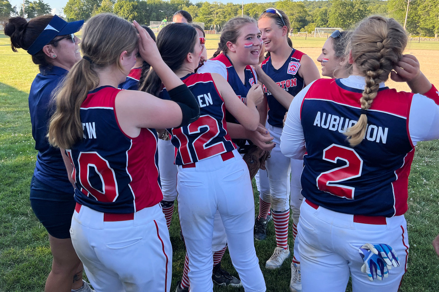 Teammates celebrate with pitcher Addie Wolf (center) after the beat South Kingstown 13-1 in the game two of the championship series at Town Farm Field on Wednesday night.