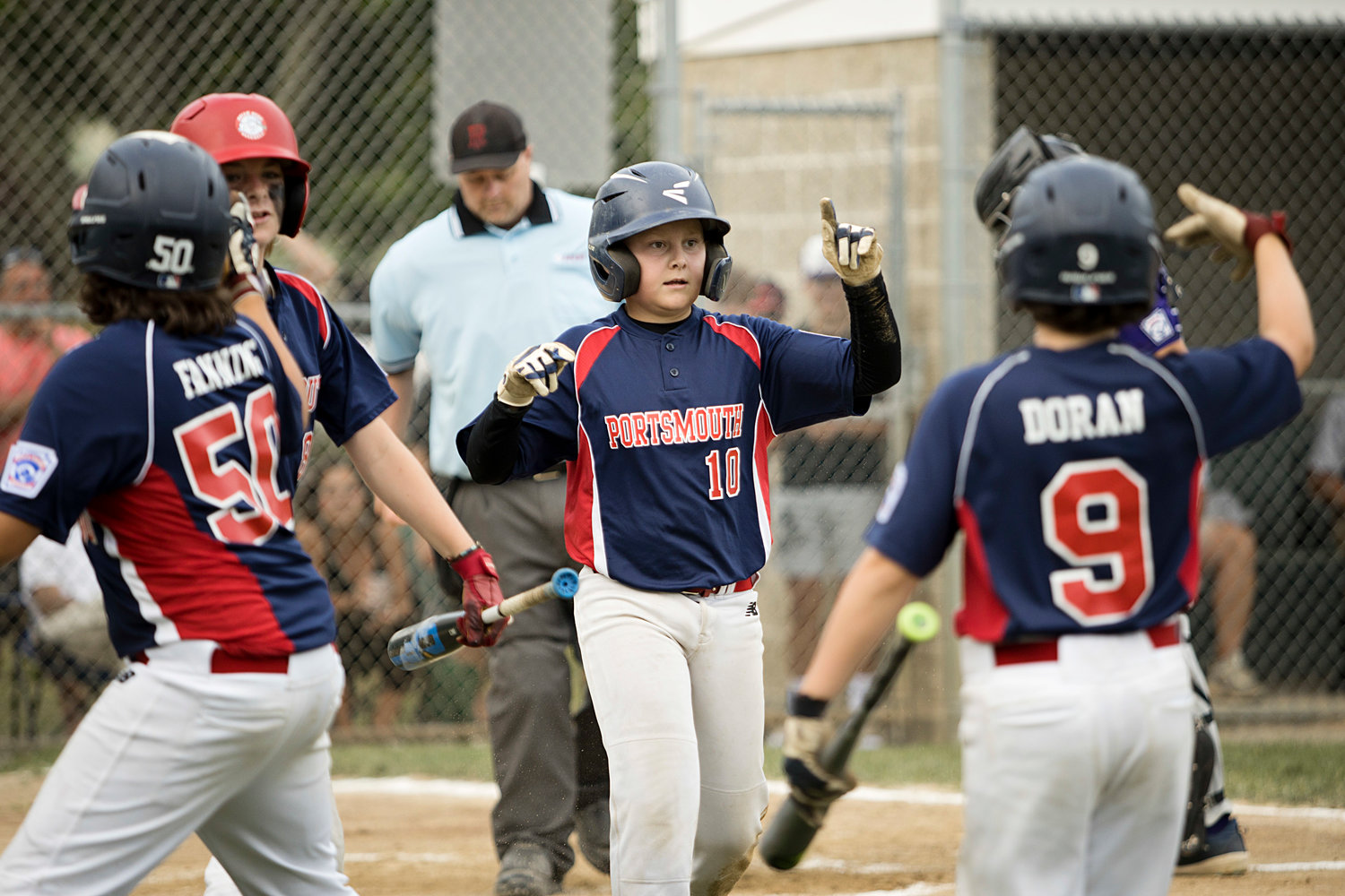 Ryan Campion (middle) celebrates with his teammates as runs come home.