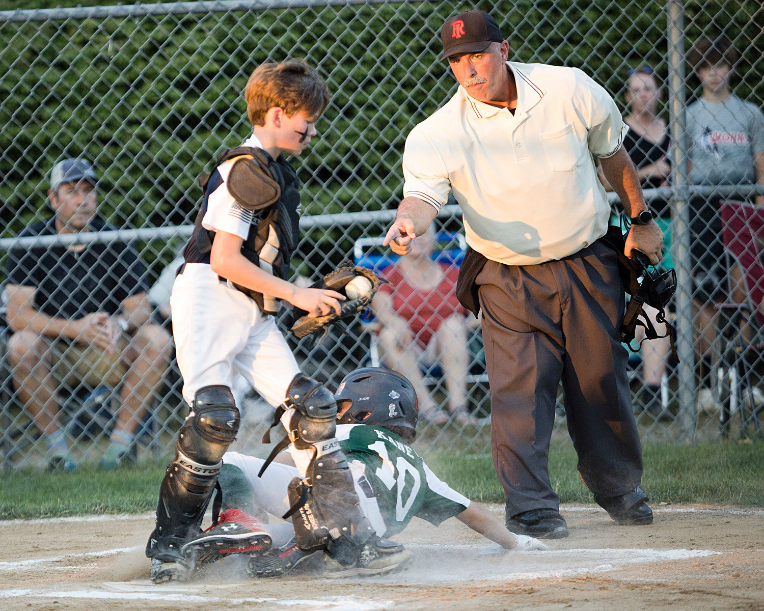 Zane Paller makes sure he has the ball while tagging a Cranston East runner out at home plate.