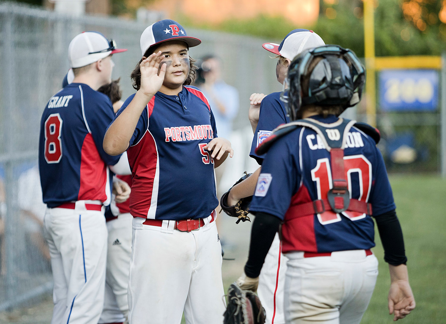 Brady Fanning congratulates his teammates as they come off of the field after a successful inning against Cumberland.