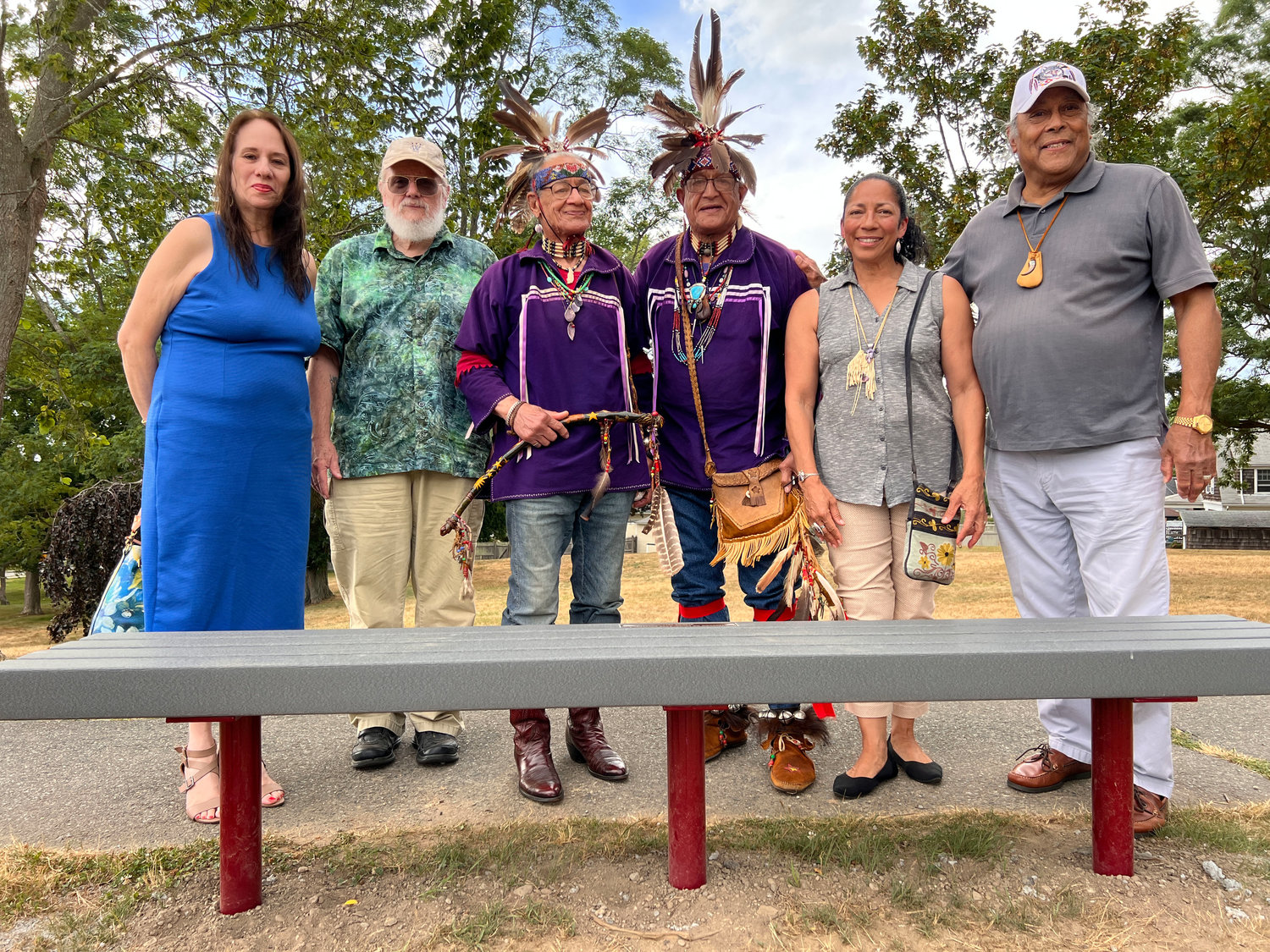 Nancy Wildes, Governor of Mayflower Descendants of RI, Ray Battcher historian for the Mayflower Descendants, Lee "Braveheart" Edmonds, Harry "Hawk" Edmonds, Sachem Dancing Star and Sagamore Po Wauipi Neimpaug pose with the new bench that was donated to them by the Mayflower Descendents of RI.