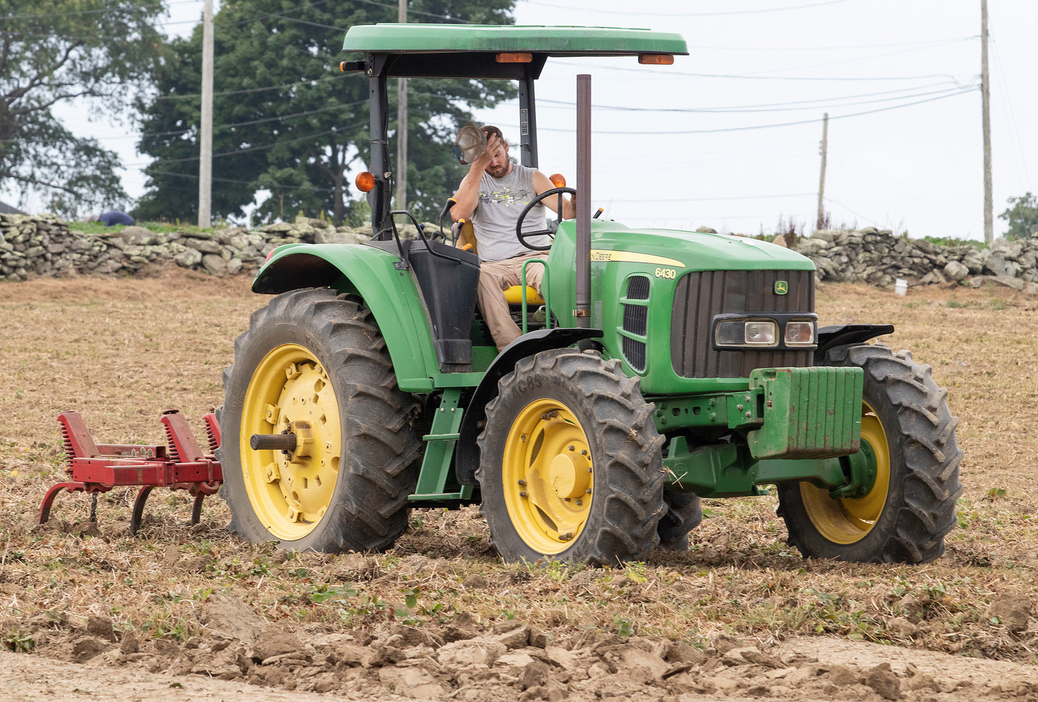 Mike Flynn of Quonset View Farm on Middle Road wipes his brow last Friday as he rotates the strawberry field’s soil in preparation for next season. The farm has been experiencing “severe drought conditions” and irrigating is expensive, Flynn said.