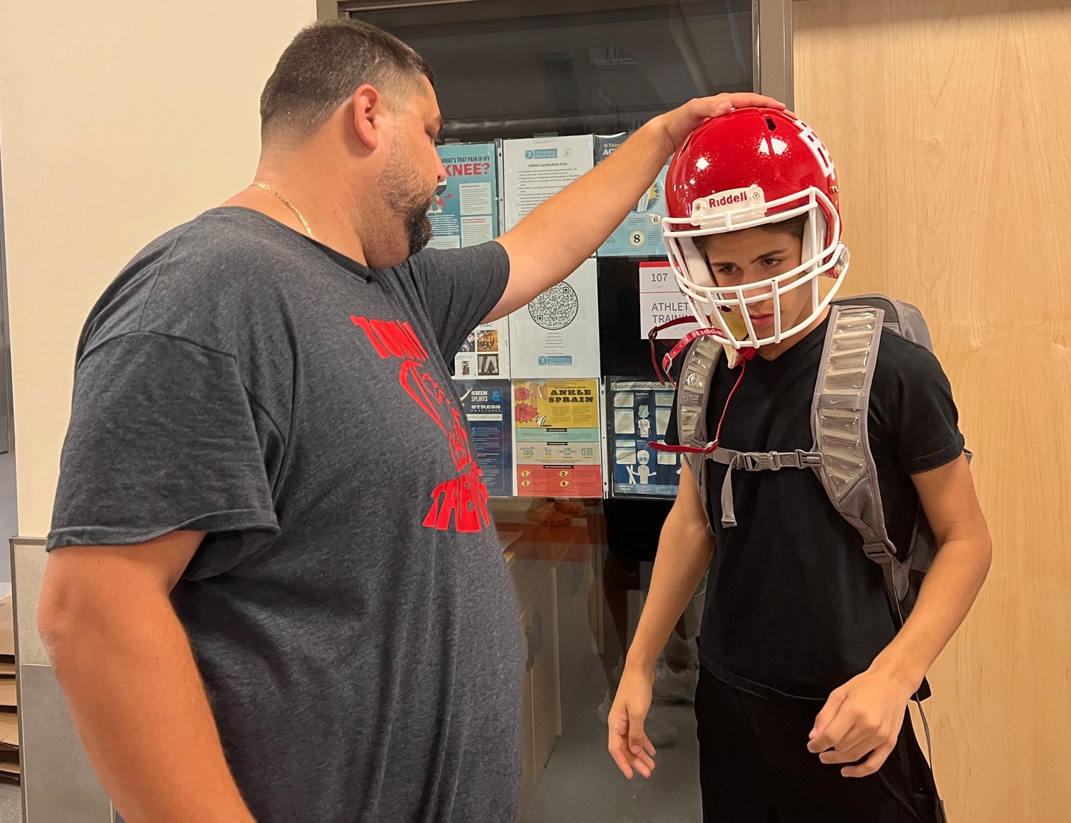 East Providence High School freshman football player Aydan Sousa is fitted for his helmet by Townies' assistant coach Eric Stringfellow earlier this week as the team readies for the official start of the upcoming 2022 season with opening day of practice Monday, Aug. 15.
