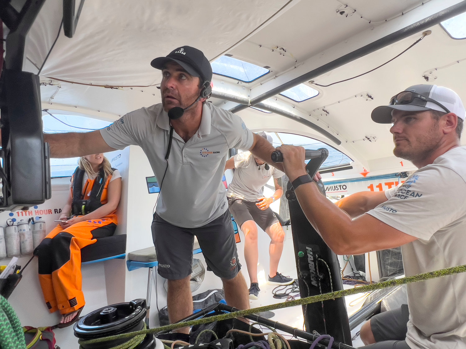 Skipper Charlie Enright (left) checks a GPS map on a touchscreen computer while James O’Mahony looks before making a tack belowdeck.