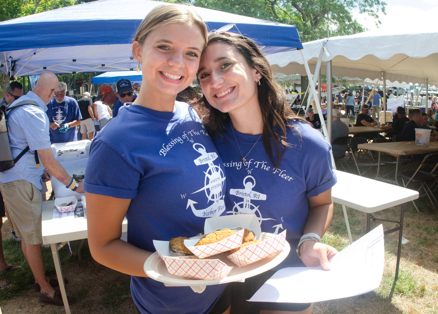 Margaret Williamsand Gabby Marsili help pose while working at the harbor festival on Saturday.