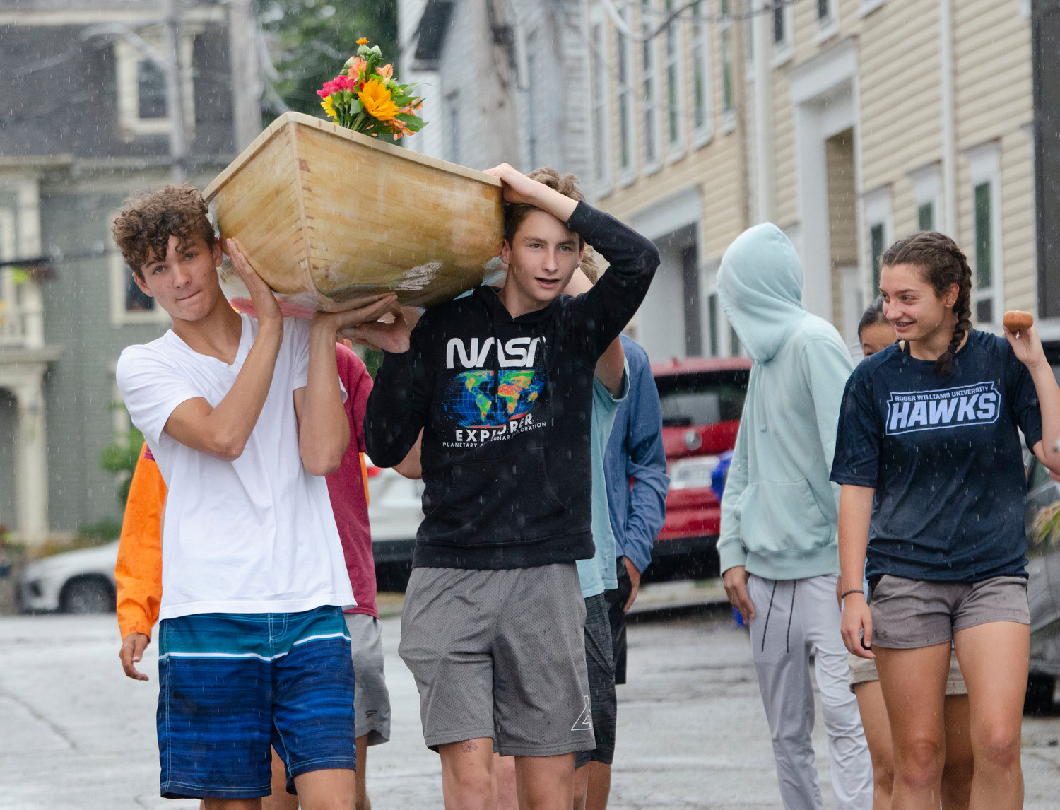 Erich Veegh (left) and Nikolas Markham of Barrington carry the boat down Burnside Street to the water.