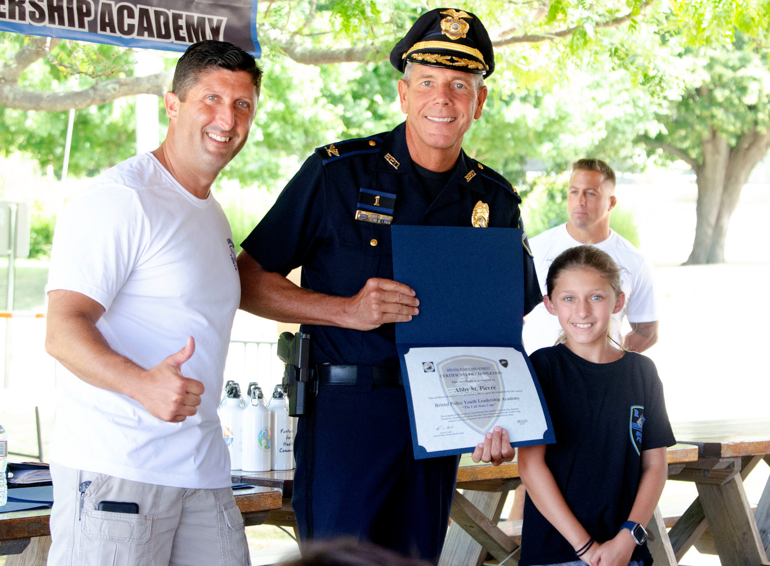 Bristol Police Lt. Steven St. Pierre (left) and Chief Kevin Lynch poses with Abby St. Pierre as leadership campers receive their diplomas on Friday at the Bristol Town Beach.
