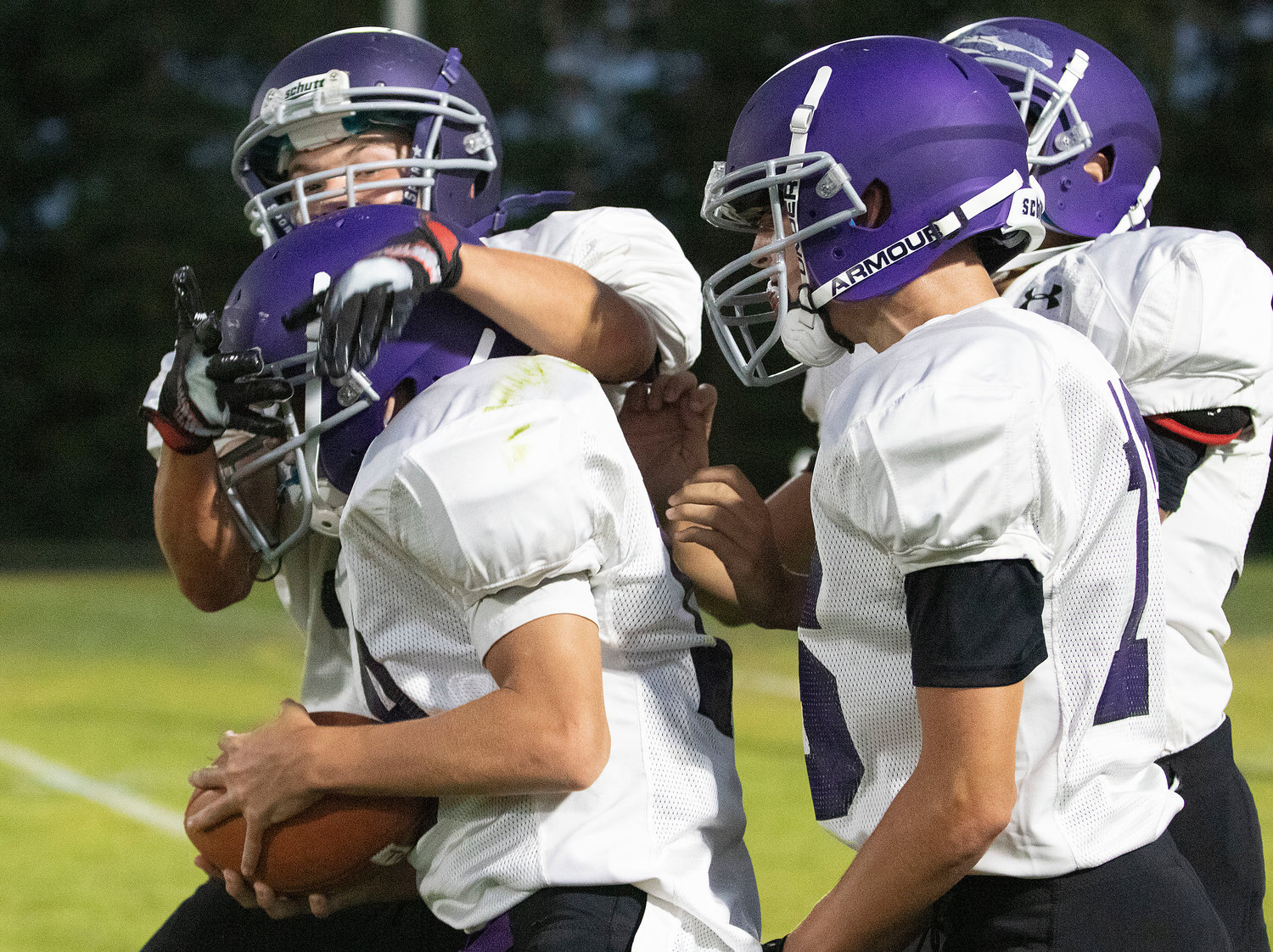Teammates celebrate with Jackson Howland (left) after he intercepts a Ben Sowa pass.