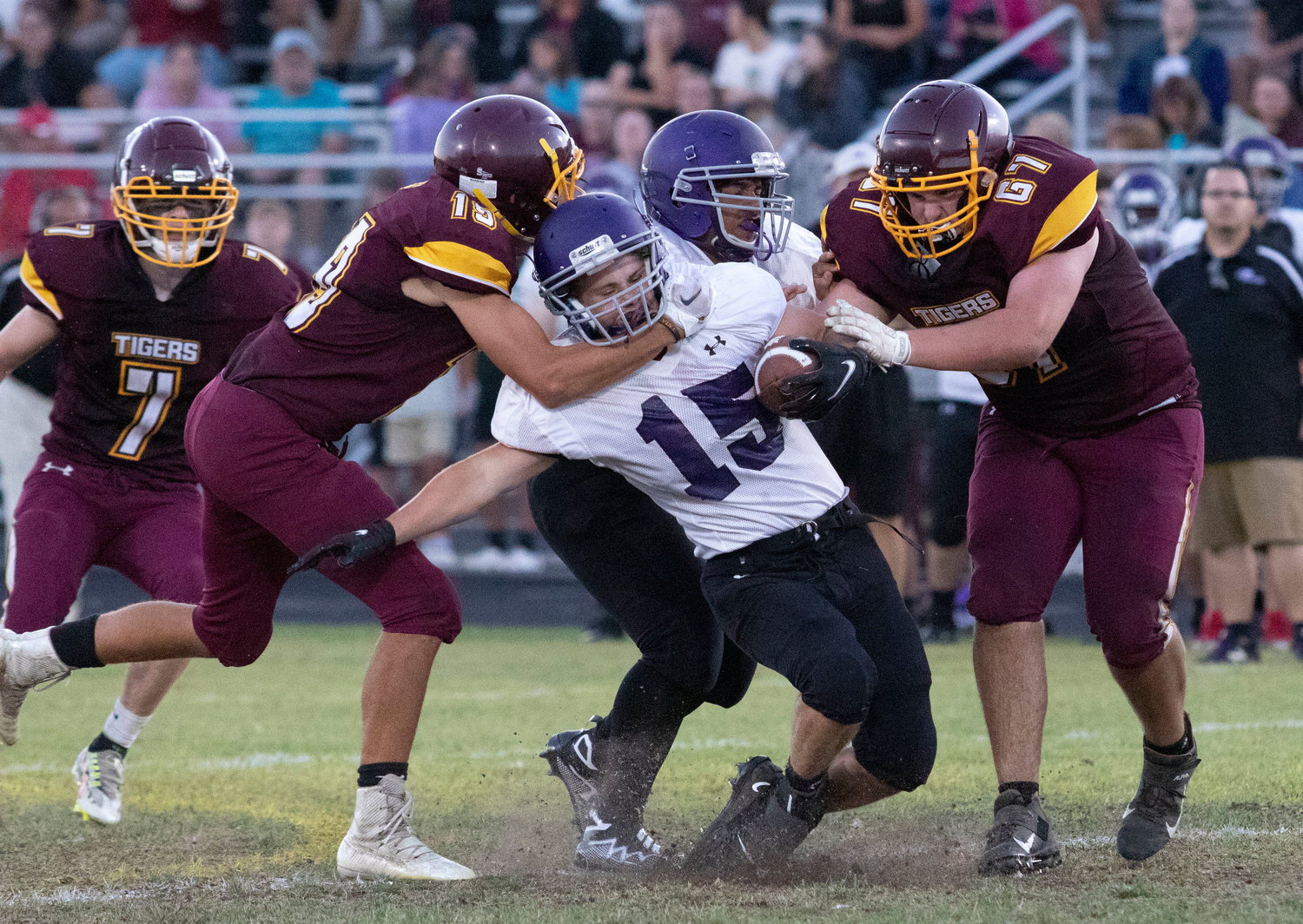 Tigers defenders Nick Reilly (left) and Tyler Garside tackle Huskies running back James Thibaudeau in the second quarter.