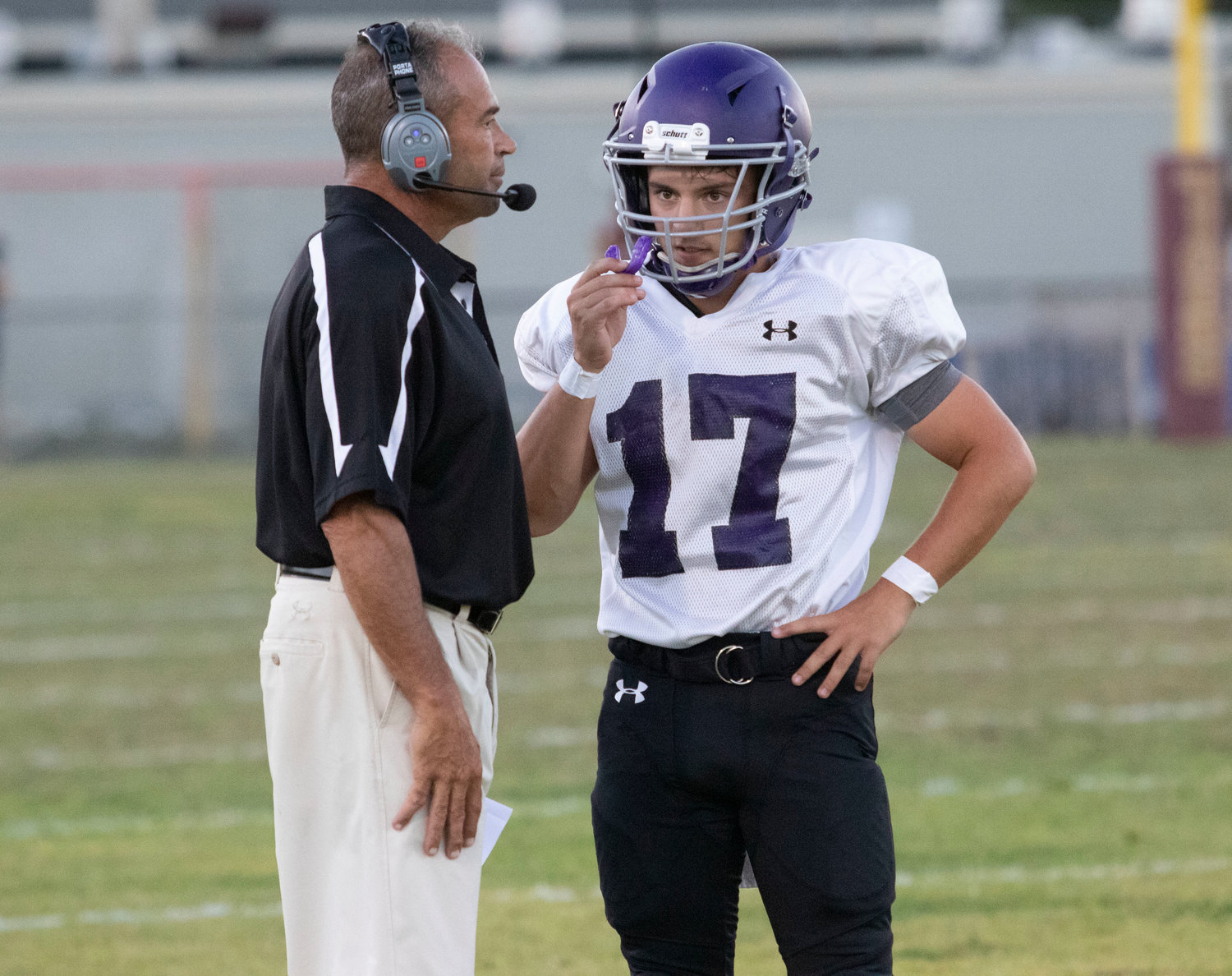 Head coach Thomas DelSanto Jr. speaks to quarterback Riley Howland between plays in the first half.