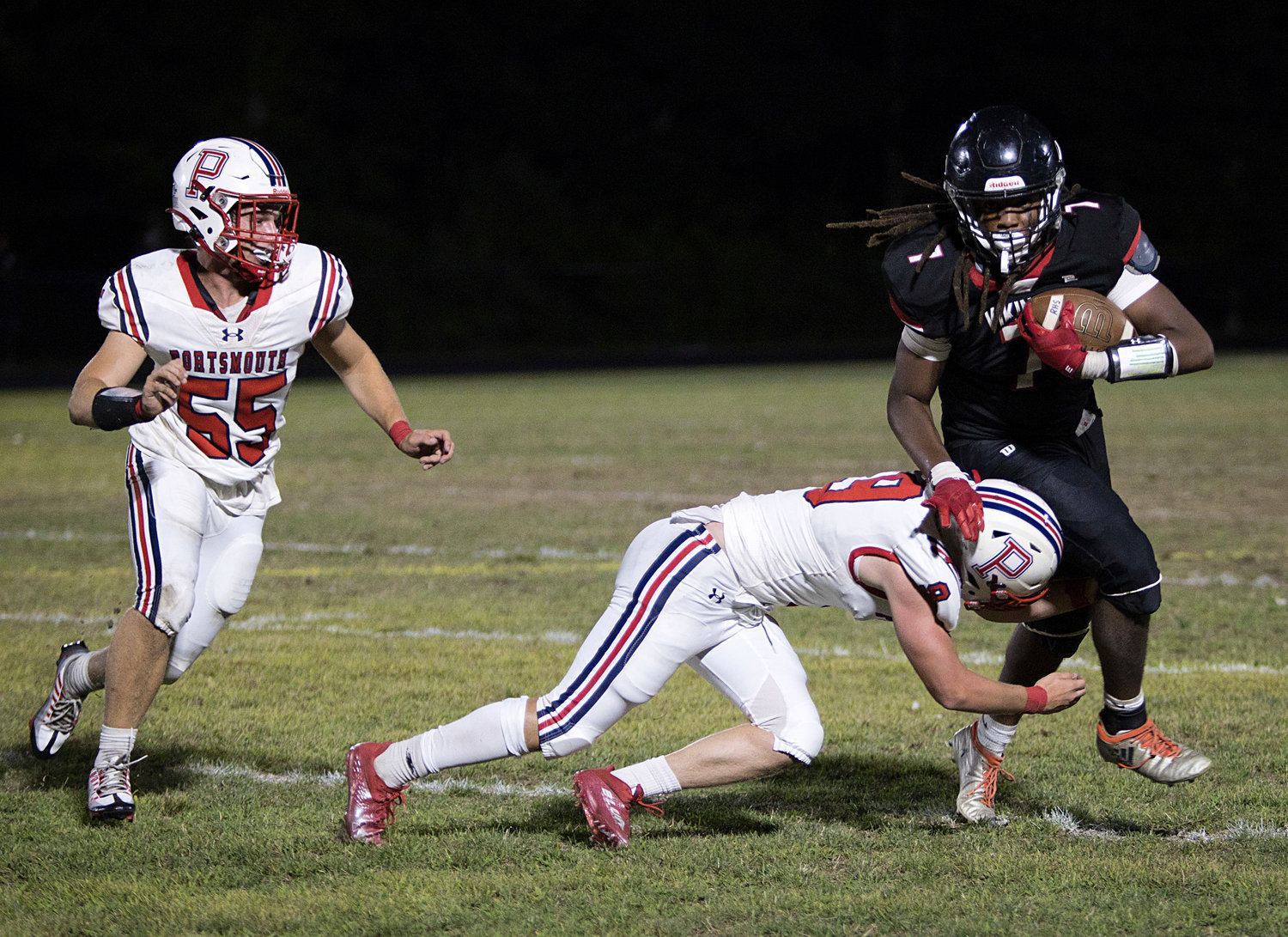 Luke Brennan dives into a Rogers opponent while playing defense for the Patriots.