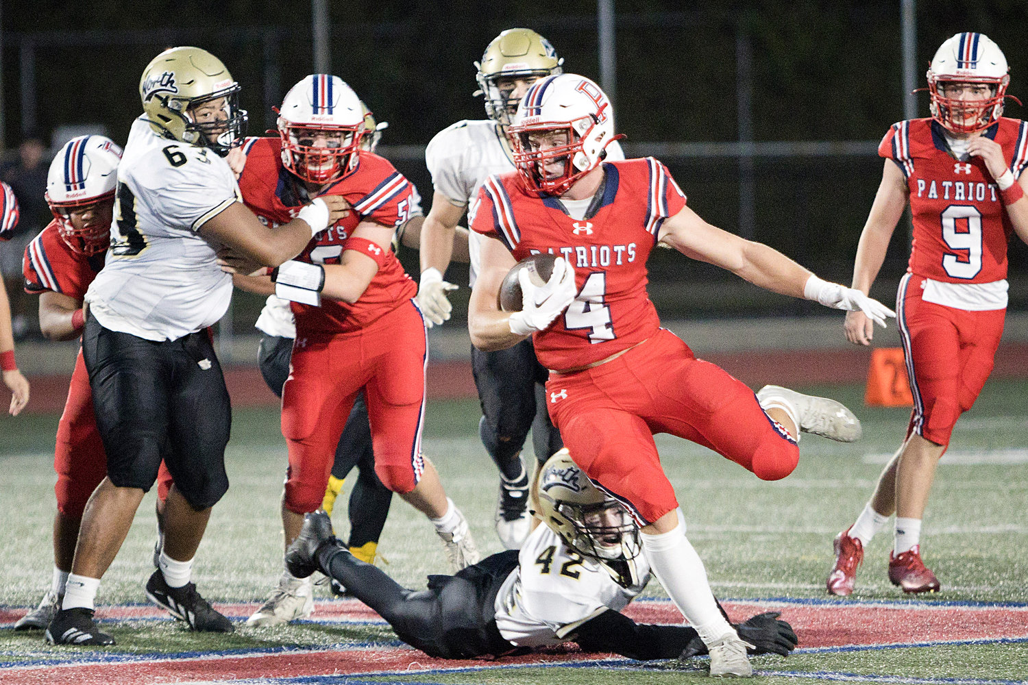 Neal Tullson barrels through the North Kingstown defense to gain yardage for the Patriots in the season-opener Friday at home. The Patriots were defeated, 20-0.