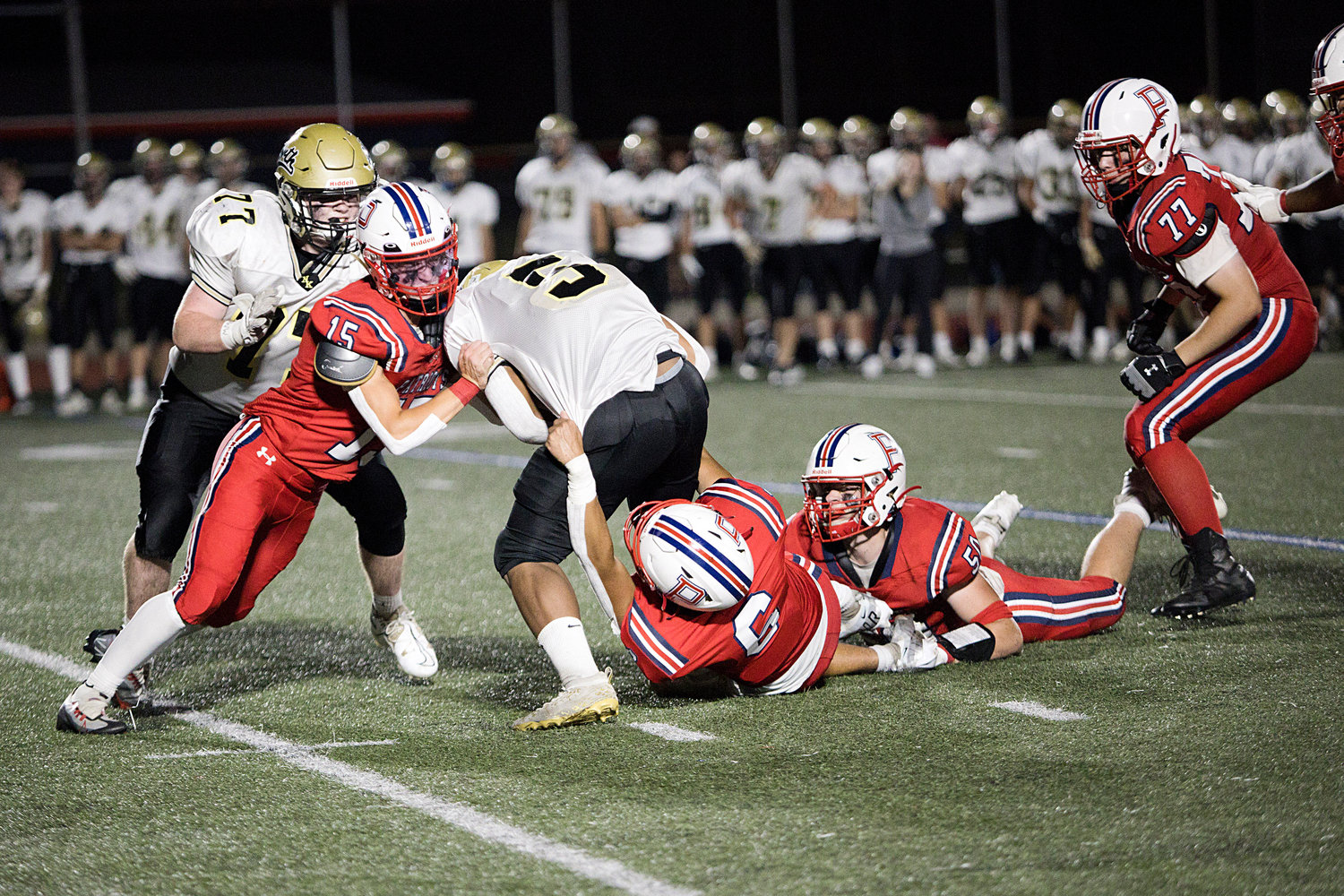 Christopher Wilkie, Michael Archer, and Tristan Conheeny (from left) work to take down a North Kingstown ball-carrier. Benjamin Blythe is at right.