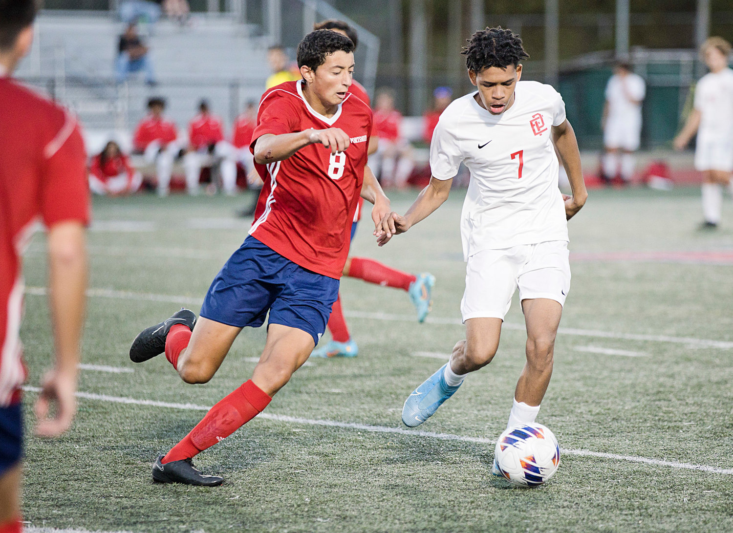 Alexis Silva controls the ball for East Providence as a Portsmouth opponent pressures him from behind.