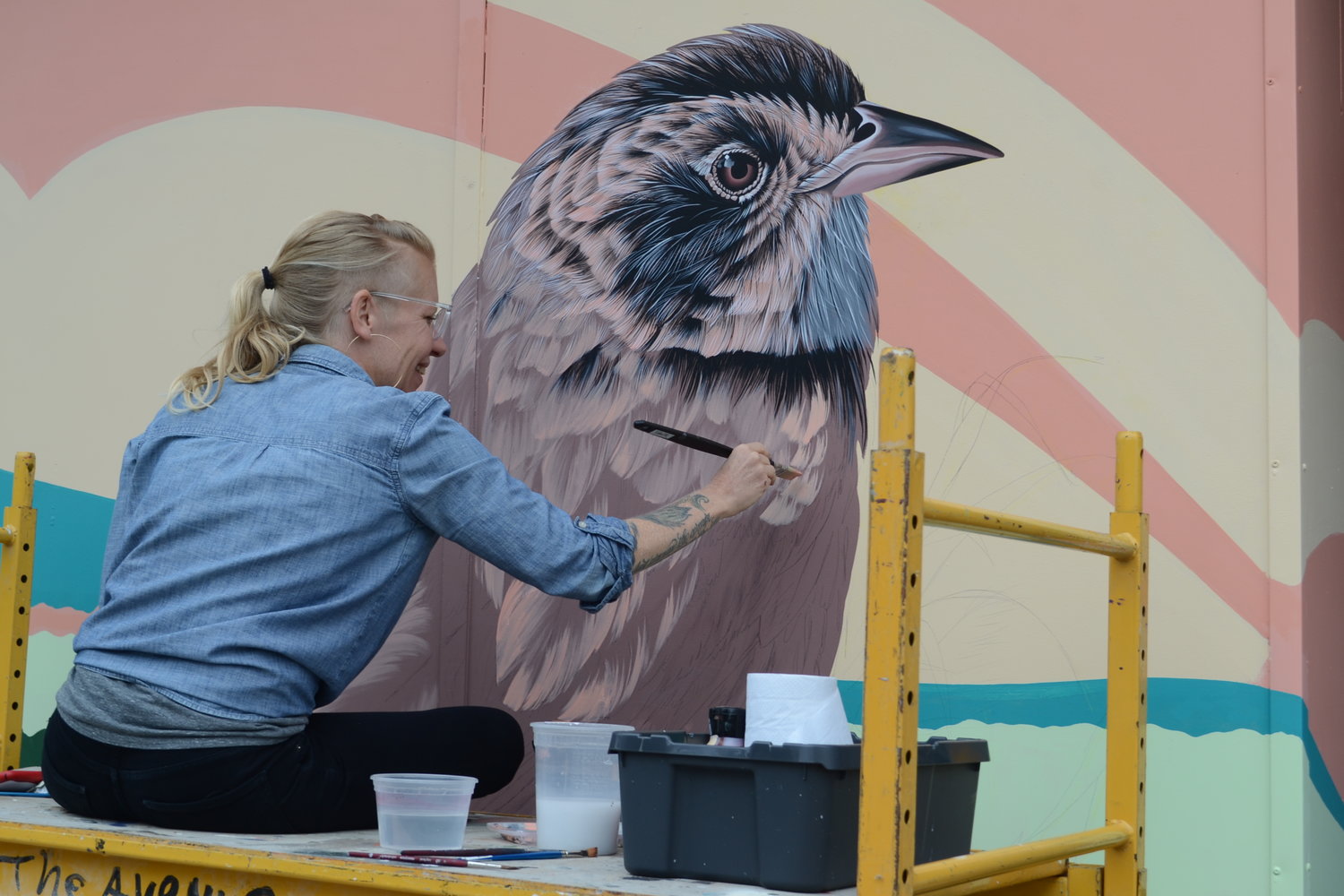 Josie Morway, a Boston-based artist and former Rhode Island resident, in the process of painting a finely-detailed saltmarsh sparrow on a storefront at 24 Child St. It is part of a mural commissioned by the Town in partnership with The Avenue Concept designed to bring awareness to the increasing concern over climate change and sea level rise.