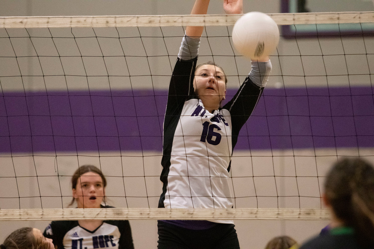 Sophomore middle hitter Abby Allen blocks a shot during the game.