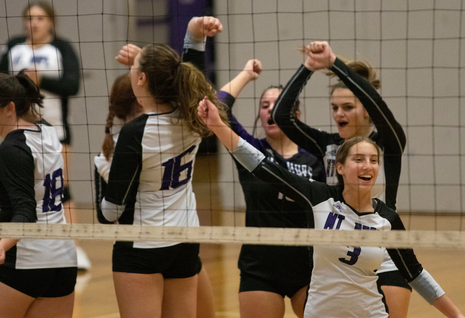 Emma Torres (right) and the team celebrate a Huskies point.