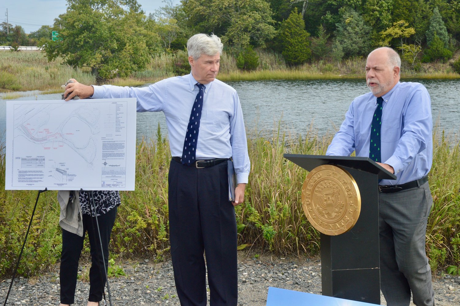 U.S. Sen. Sheldon Whitehouse holds a graphic showing the proposed project while RIDEM Director Terry Gray speaks.