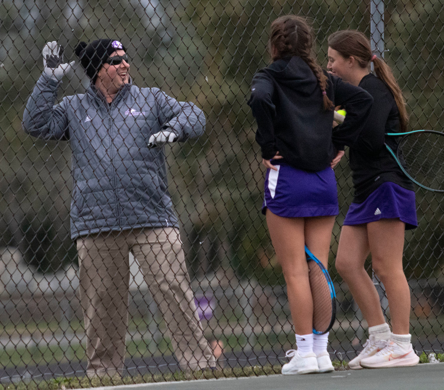 Head coach Geoff Keegan speaks to a doubles team during their match against Barrington on Monday. He has kept the team upbeat and positive as they compete in Division I.
