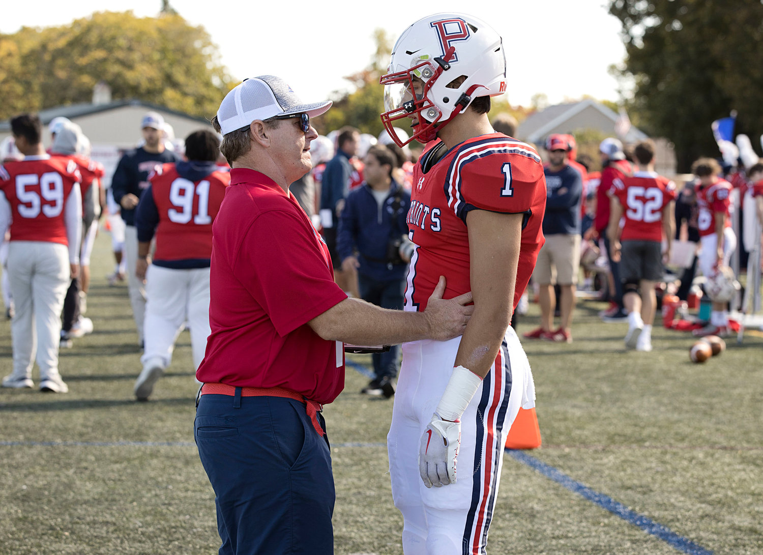 Head coach Dustin Almeida talks with Carson Conheeny before Saturday's Homecoming game.