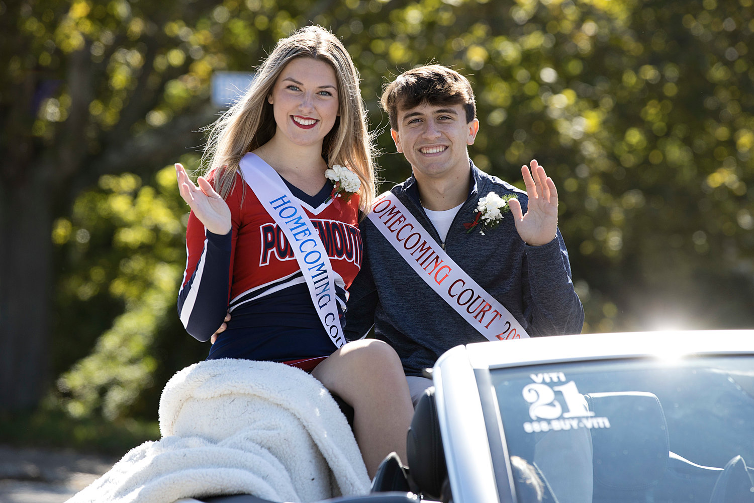 Phoebe Tavares and Andrew Alvanas of the Homecoming court wave from their car.