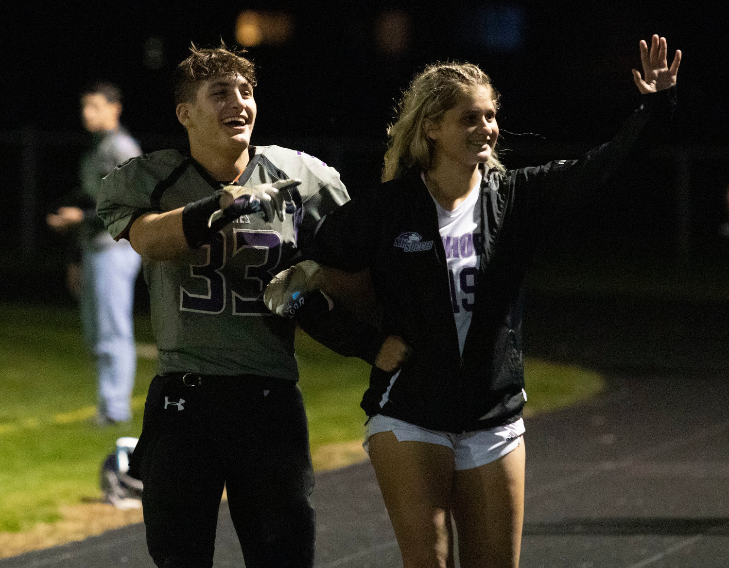 Brock Pacheco and soccer player Abby Razzino are announced to the crowd during the Homecoming game.