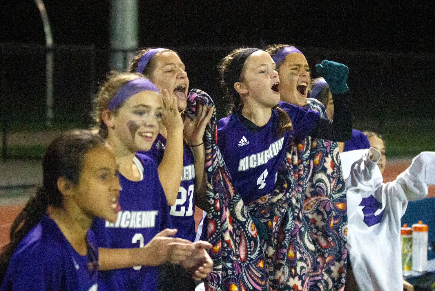 Maya Goglia (left), Ava Morissette, Norah Francis, Catherine Frawley and others cheer on their teammates from the bench.
