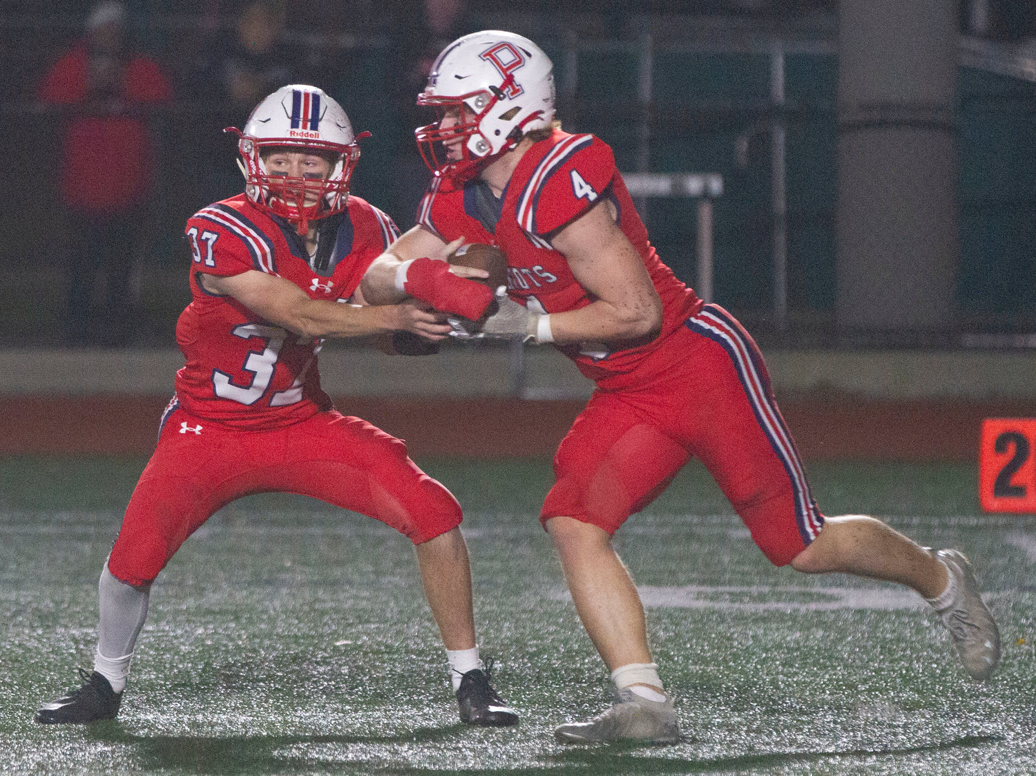 Portsmouth quarterback Adam Conheeny hands off to senior running back Neal Tullson in the first quarter to start a must-needed drive against East Providence during Friday’s Division II quarterfinal game.