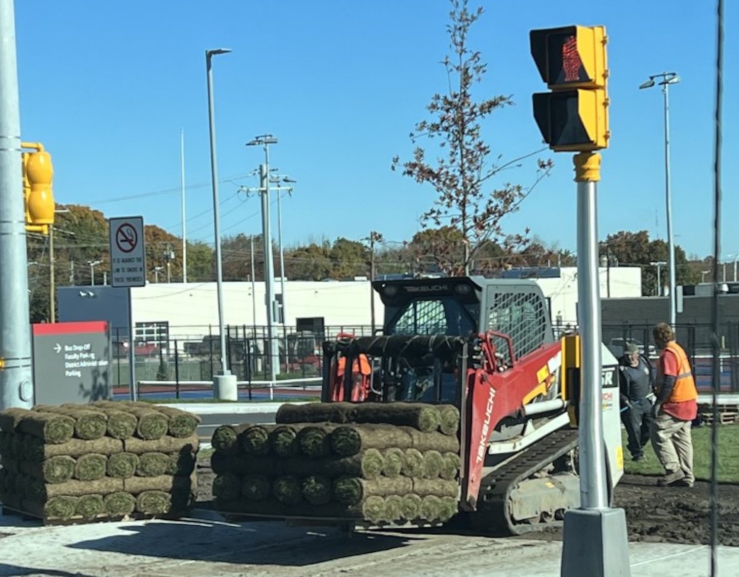 Workers install sod on the grounds of the high school on Saturday, Oct. 29.