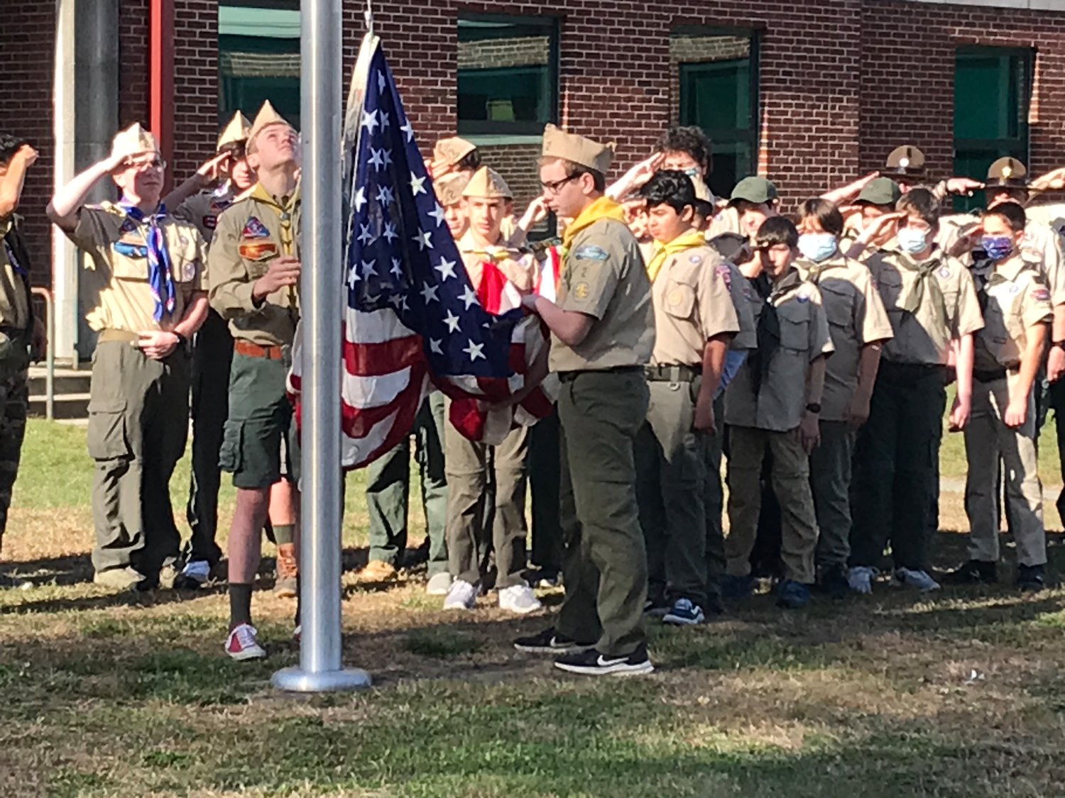 A group of Boy Scouts raise the American flag during last year's Veterans Day ceremony outside Barrington High School.