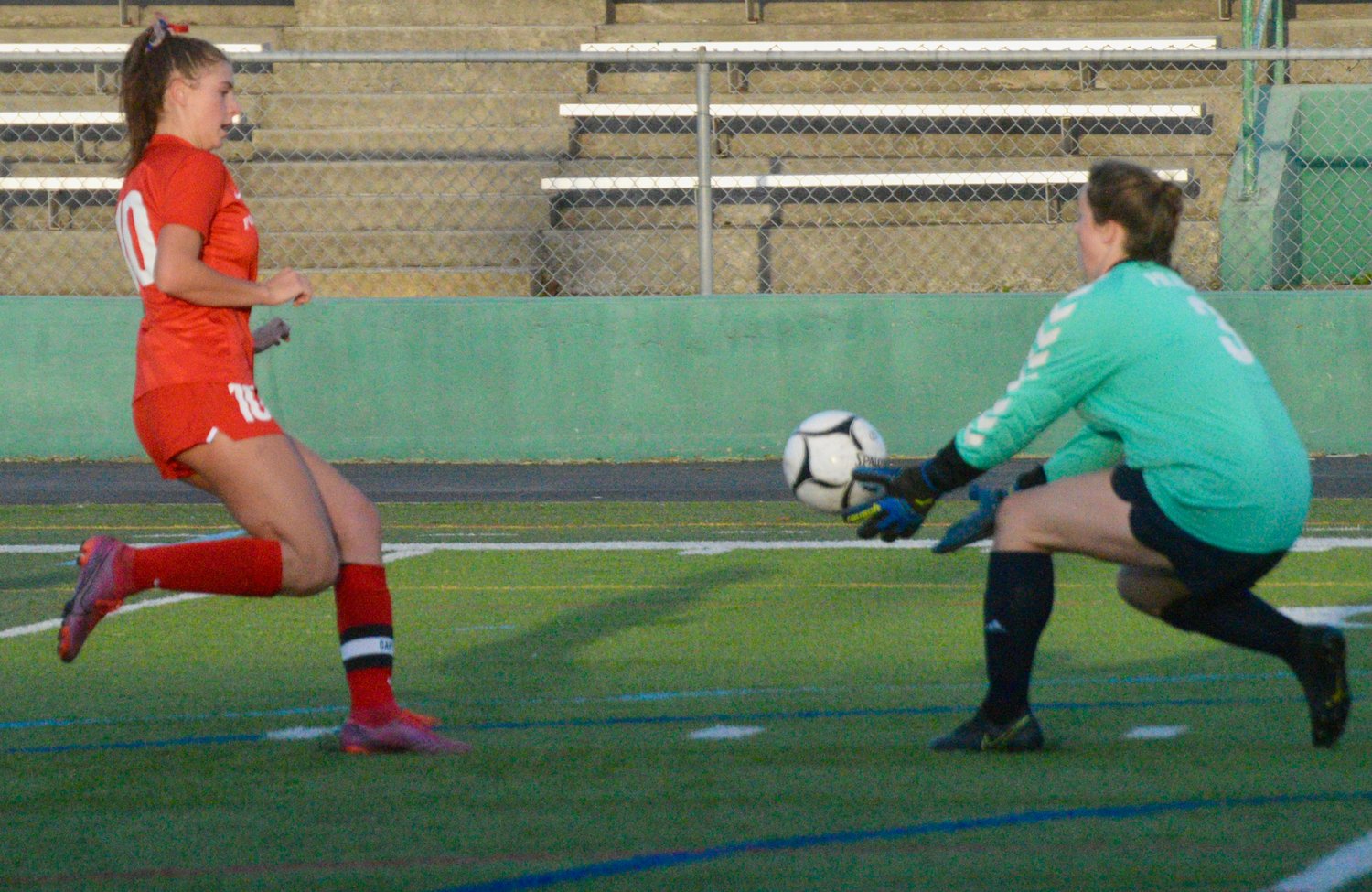 Senior Kaitlin Roche closes in quickly as the Burrillville goaltender comes out of net to make a save.