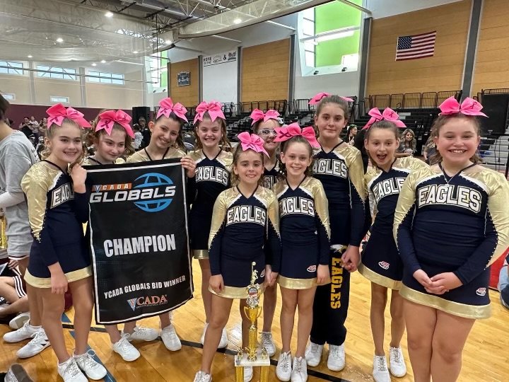 Members of the Barrington Pop Warner Pee Wee cheer team show off their championship banner and trophy after the recent competition.