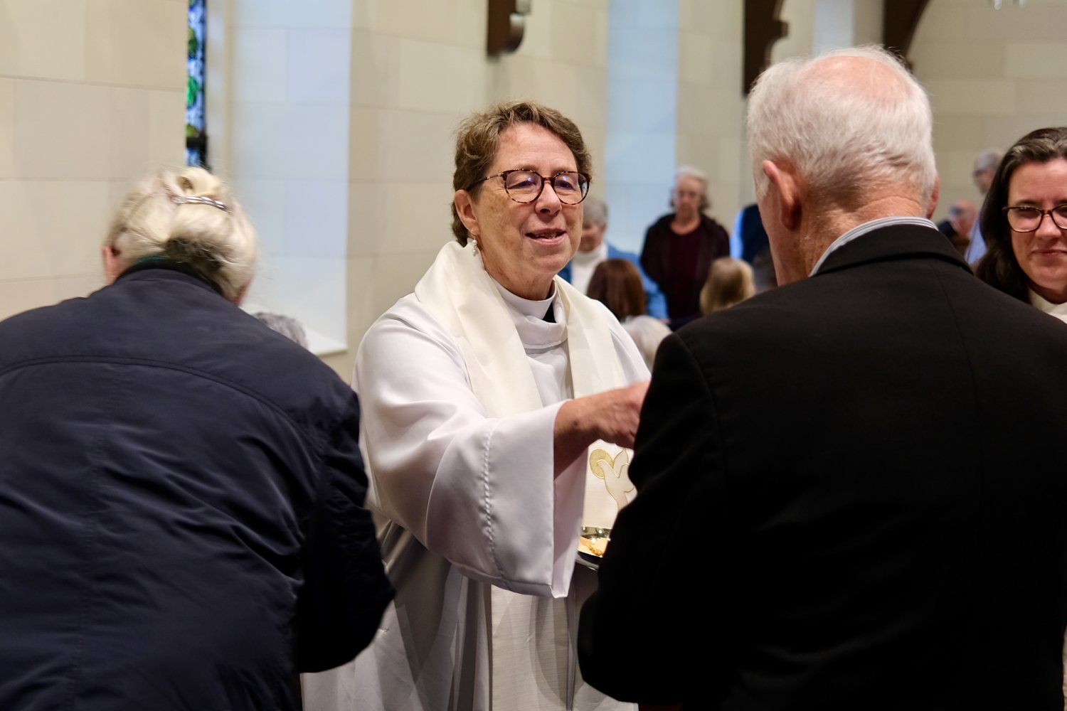 The Rev. Pamela Mott gives communion to a parishioner.