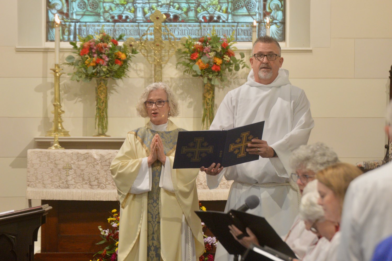 Paul Westrom, who led the first two phases of the church renovation project, holds a book of readings for The Rev. Jennifer Pedrick, rector of St. Mary’s Episcopal Church.